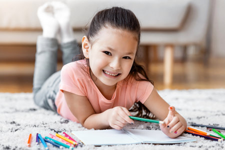Cute Little Girl Drawing Lying On Floor At Homeの写真素材