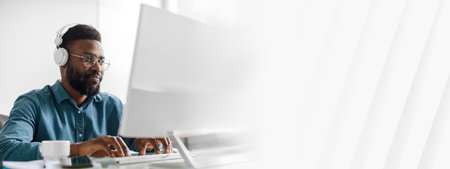 Young African American businessman focused on work in modern office settingの写真素材