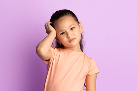 Young sad girl touching head looking at cameraの写真素材