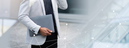 Business professional on a call with a laptop in a modern settingの写真素材