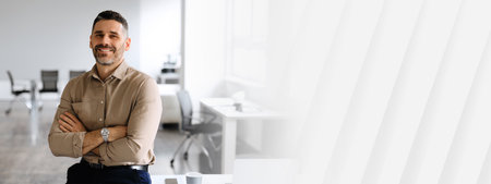Successful businessman. Confident man in shirt sitting on desk, posing with folded arms, smiling at camera, copy spaceの写真素材