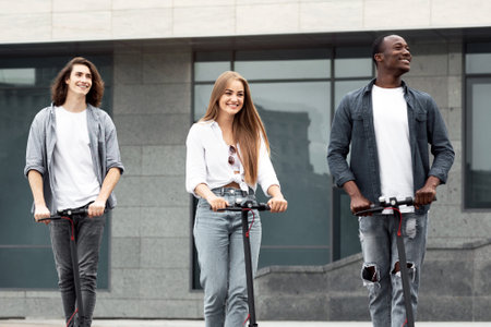 Friends having nice ride on motorized scootersの写真素材