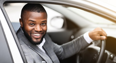 Cheerful successful black businessman looking through car windowの写真素材