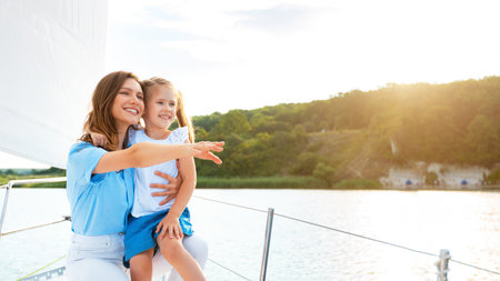 Happy Mother And Daughter On Yacht Deck Enjoying Boat Rideの写真素材