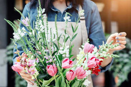 Woman florist at her own floral shop taking care of flowersの写真素材