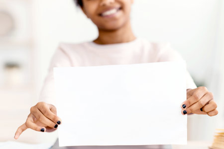 Girl Showing Tag Smiling To Camera Sitting Indoorの写真素材