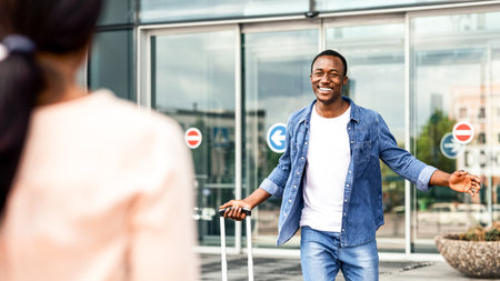 Happy black man meeting his girlfriend after landing at airportの写真素材