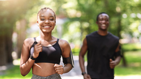 Active Lifestyle Concept. Motivated African Girl Jogging Outdoors With Her Male Friend