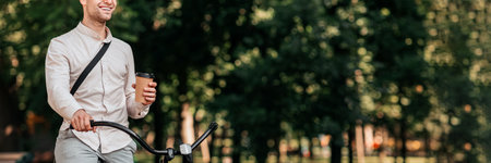 Young man enjoys coffee while riding bike through urban park