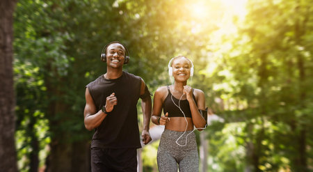Morning Jogging Concept. Motivated Black Couple Running Together In Summer Parkの写真素材