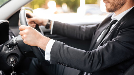 Unrecognizable businessman holding hands on steering wheel, driving carの写真素材