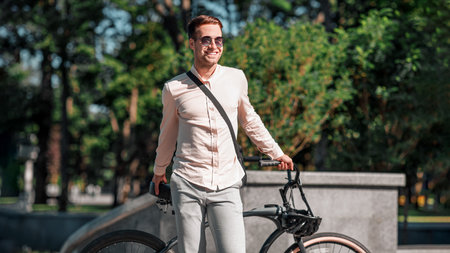 Portrait of hipster businessman in sunglasses with bicycle standingの写真素材
