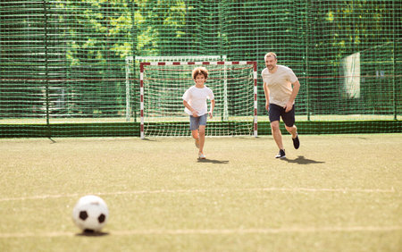 Sportive dad playing football with his sonの写真素材