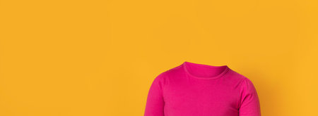 Headless figure wearing pink shirt against a bright yellow backgroundの写真素材