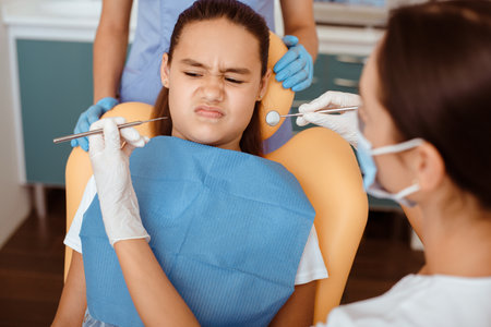 Portrait of little girl with suspicion looks at medical toolsの写真素材