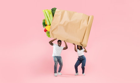 Happy couple joyfully shopping with a large paper bag of groceries