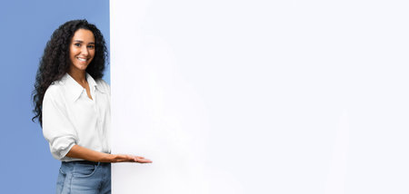Place For Your Ad. Smiling brunette woman pointing at white advertisement boardの写真素材