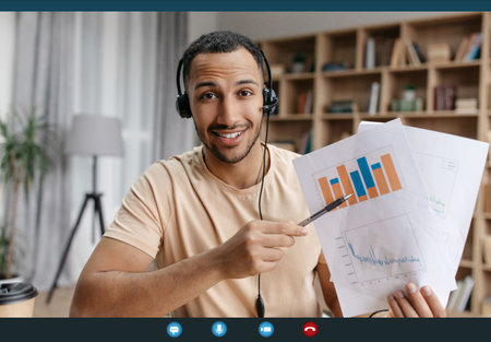 Happy arab businessman making teleconference with colleagues from home, showing reports with graphs and chartsの写真素材