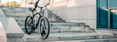 Young man riding bike down stairs in urban environmentの写真素材