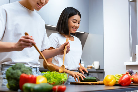 Happy Chinese Family Couple Cooking Preparing Tasty Dinner In Kitchenの写真素材