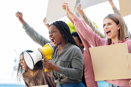 Emotional international students making strike on the street, side viewの写真素材