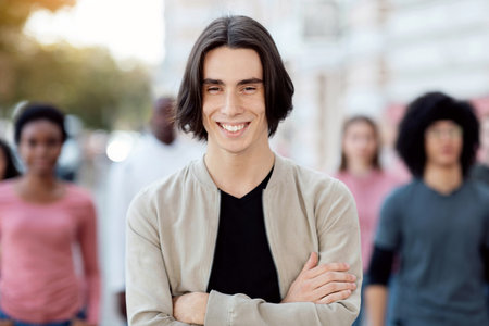 Cheerful young man standing over multiracial crowd on street