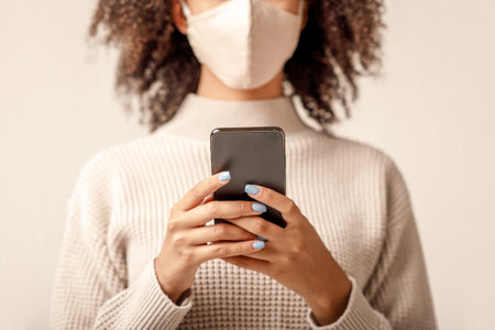 News about spread of virus in world and social networks. African americans lady typing on smartphoneの写真素材