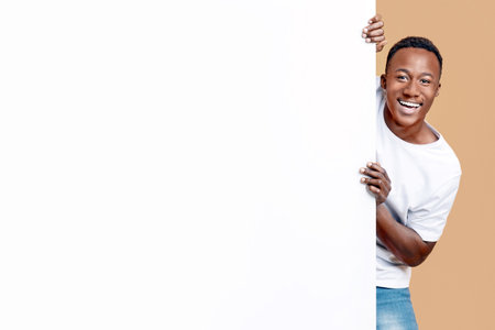 Cheerful african american couple standing by empty board for advertisement