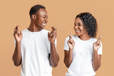 Couple crossing fingers with hope and looking at each otherの写真素材