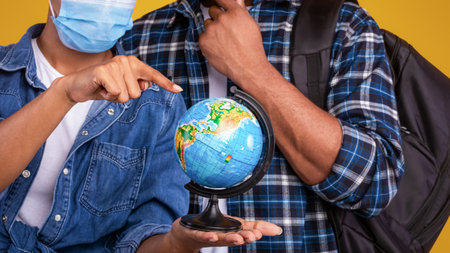 African Couple Holding Globe Choosing Coronavirus-Safe Travel Destination, Studio Shotの写真素材
