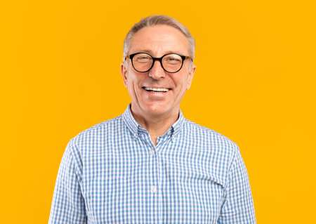 Portrait of smiling mature man in glasses posing at studio