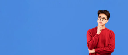 Portrait of pensive asian man looking up at studio