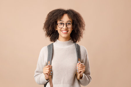 Happy african american woman in glasses, with backpack ready for study after covid-19 quarantineの写真素材