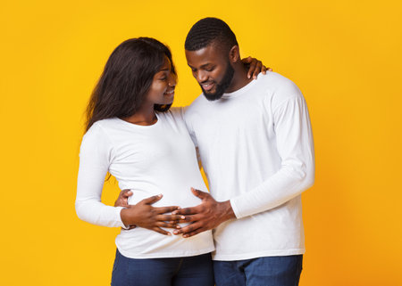 Man in love touching his pregnant wife tummyの写真素材