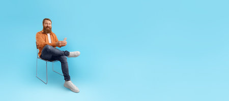 Man relaxed on chair using smartphone against blue background