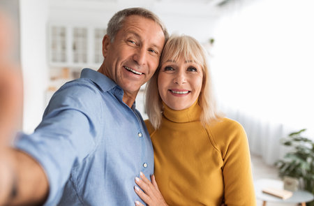 Happy Senior Couple Making Selfie Hugging Standing At Home