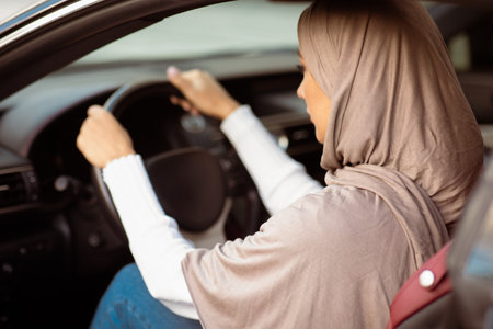 Rear view of muslim woman driving her new carの写真素材