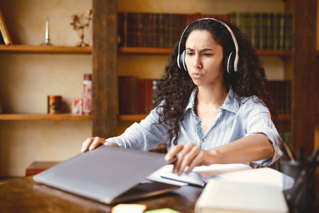Tired woman sitting at desk, closing or opening laptop computer