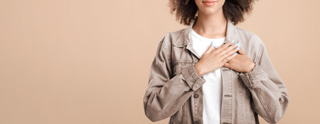 Pleased young female with closed eyes feeling love, desire, gratitude, appreciation and thanking fateの写真素材