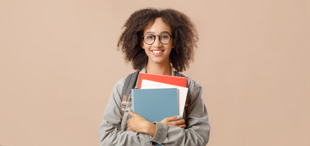 Preparation for lessons. Studio shot of glad african american female student in glasses with...