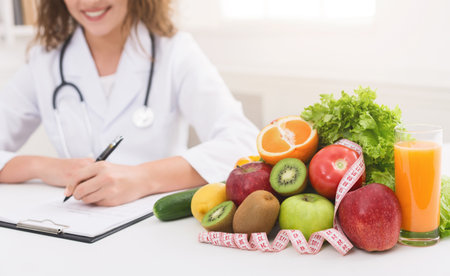 Female nutritionist doctor writing vegetable diet planの写真素材