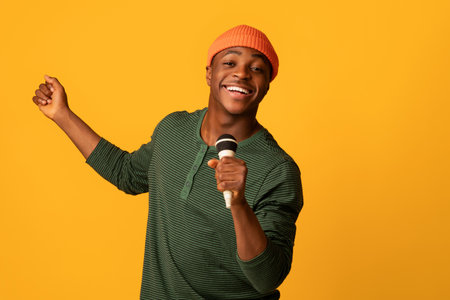 Cheerful Black Millennial Guy Holding Microphone And Singing At Camera