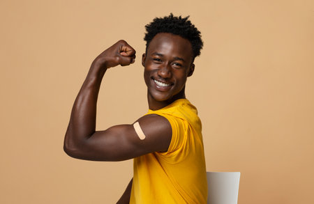 Happy Black Guy Showing Arm With Adhesive Bandage After Covid-19 Vaccination Shotの写真素材