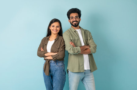 Smiling millennial eastern man and woman standing back to back
