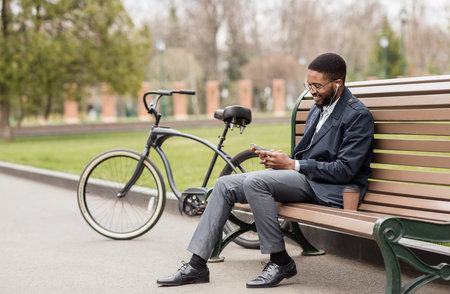 Man in earphone sitting on bench listening to radioの写真素材