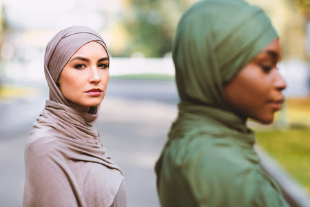 Two Diverse Muslim Women Posing Outdoors, Wearing Traditional Hijabの写真素材