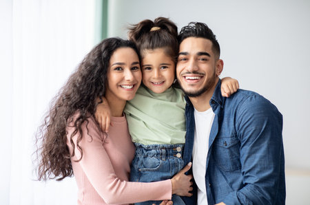 Portrait Of Happy Middle Eastern Family Of Three Posing Together At Homeの写真素材