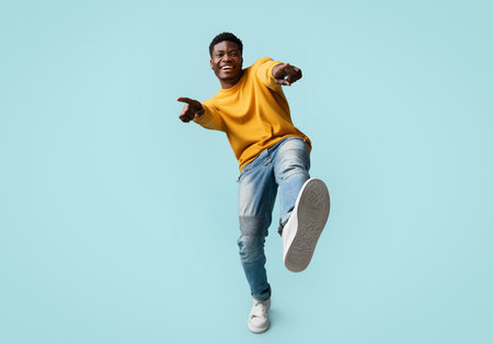 Carefree handsome black guy posing on blue, laughing and gesturingの写真素材
