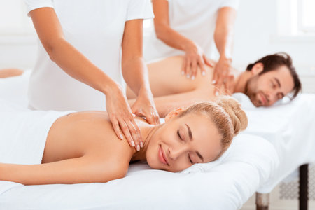 Relaxed Girlfriend And Boyfriend Enjoying Massage Lying On Beds Indoorsの写真素材