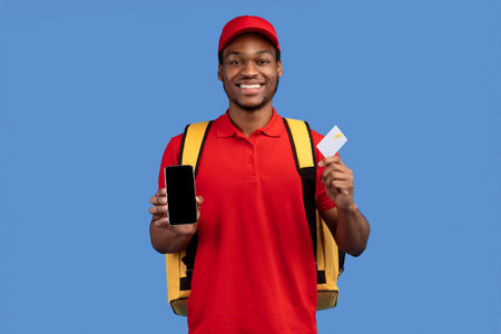 African american courier showing credit card and mobile phoneの写真素材